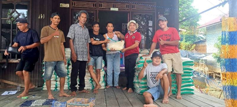 BANTUAN DARI ANGGOTA DPRD-Warga Desa Bintang Ninggi II membagikan bantuan beras dari salah satu anggota DPRD Barito Utara Dapil 4, Ardianto, di Desa Bintang Ninggi II, Jumat (25/4).